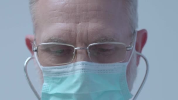 Ιατρός με μάσκα που εξετάζει τον ασθενή, χρησιμοποιώντας στηθοσκόπιο, υγειονομική περίθαλψη — Αρχείο Βίντεο
