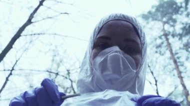 Adli tıp koruyucu giysi uzmanı plastik torba ve suç mahallinde kurşun topluyor.