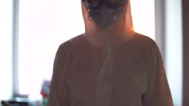 Hastalıklı bölgede koruma altında olan doktor, hastayı ve virüsü muayene ediyor.