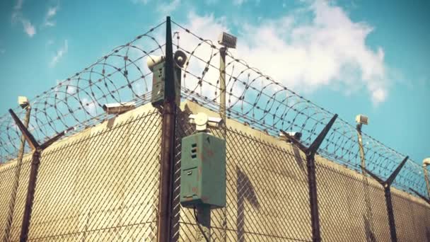 Камера видеонаблюдения за забором из колючей проволоки, записи с камер наблюдения, тюрьма — стоковое видео