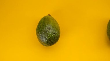 Avokadoların sarı arkaplandaki hareketini durdur, 4k