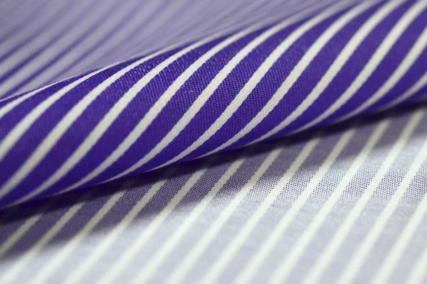 Primer plano rollo púrpura y tela blanca de camisa — Foto de Stock