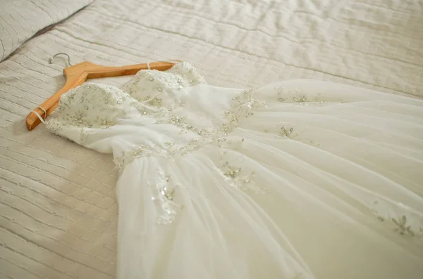 Hochzeitskleid auf dem Bett — Stockfoto