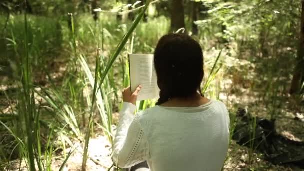 Menina lendo na floresta — Vídeo de Stock