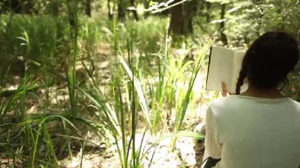 Menina lendo na floresta — Vídeo de Stock