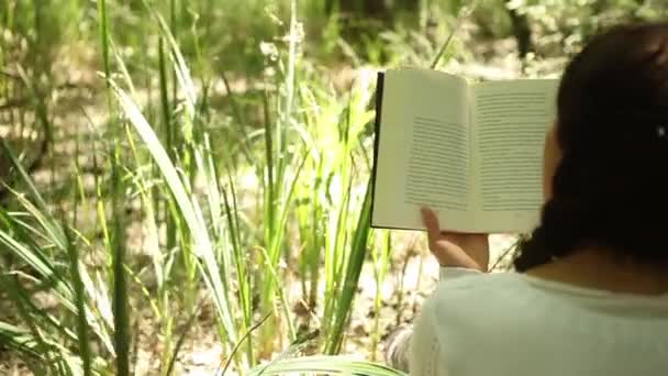 Chica leyendo en el bosque — Vídeo de stock