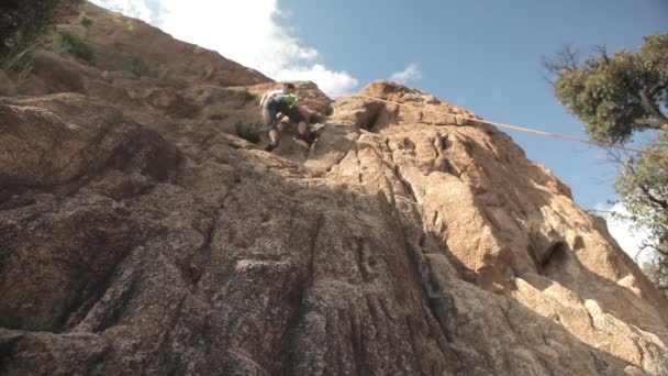 Femme grimpant sur un rocher — Video