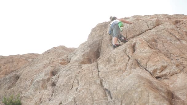 Femme grimpant sur un rocher — Video