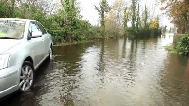 Coche en una carretera inundada — Vídeo de stock
