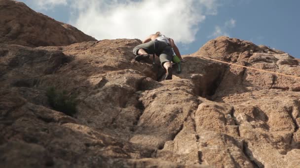 Mujer trepando en una roca — Vídeo de stock