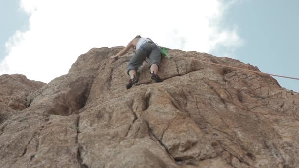 Frau klettert auf einen Felsen — Stockvideo