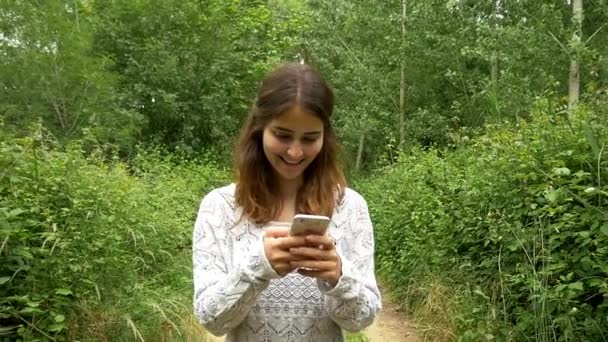 जंगल में स्मार्टफ़ोन का उपयोग करने वाली लड़की — स्टॉक वीडियो