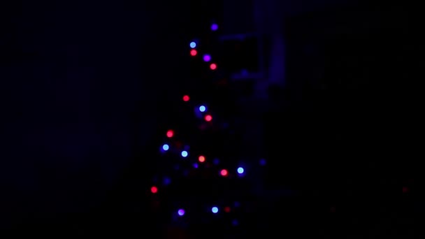 Kerstboom met decoraties in duisternis — Stockvideo