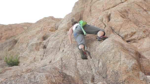 Frau klettert auf einen Felsen — Stockvideo