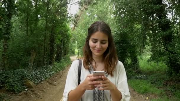 Lány használ smartphone-erdő — Stock videók