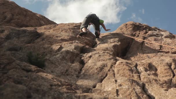 Femme grimpant sur un rocher — Video