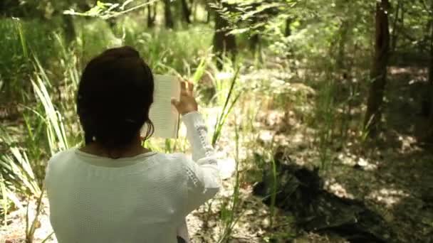 Διαβάζοντας στο δάσος κορίτσι — Αρχείο Βίντεο