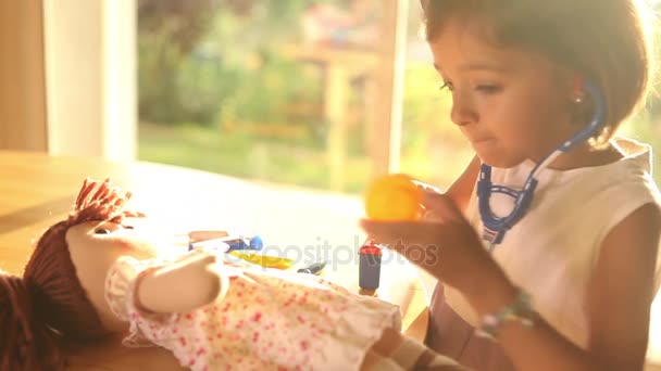 Chica jugando doctores con muñeca — Vídeo de stock