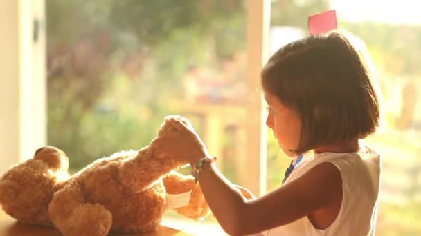 Menina jogando médico com ursinho de pelúcia — Vídeo de Stock