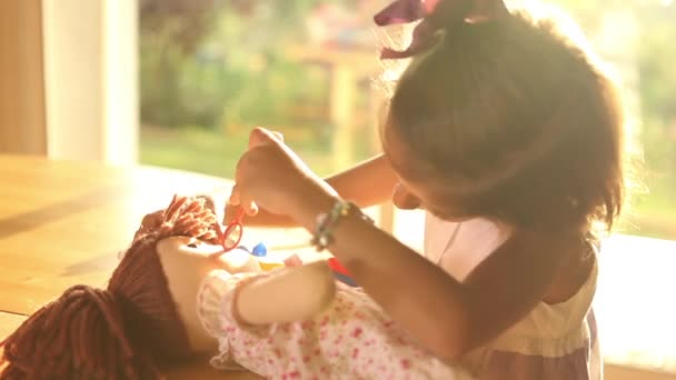 Девушка, играющая в доктора с куклой — стоковое видео