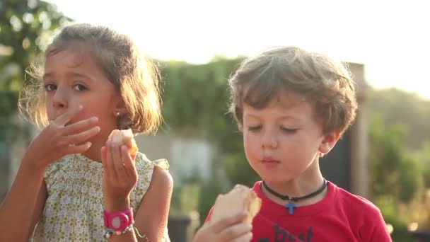 Junge und Mädchen essen Snack — Stockvideo