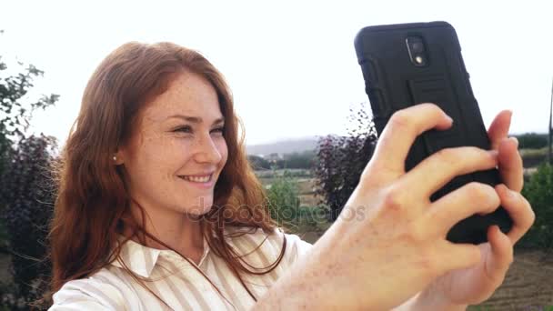 Fiatal vöröshajú lány vesz selfie — Stock videók