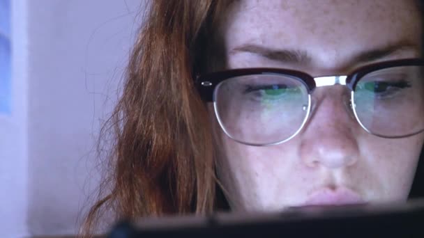 Jonge roodharige meisje in glazen met tablet — Stockvideo