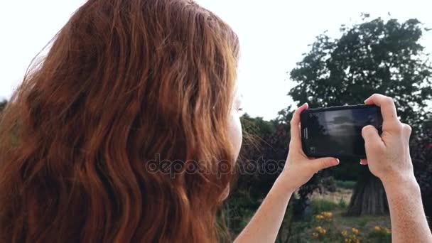 Unga rödhårig tjej med foto — Stockvideo