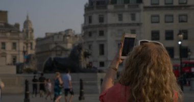 Londra, İngiltere - 23 Haziran 2017: smartphone ya da sembolik manzaraları Londra, Trafalgar Meydanı, Nelson's column iphone ile fotoğraf çekmek turist kadın