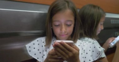 Asansörde cep telefonu akıllı telefon yeni teknoloji kullanan küçük şirin güzel kız