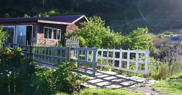 英国庭院与白色篱芭 热带植被和木旅馆在山村 — 图库视频影像