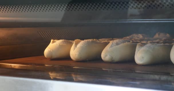 贝克做面包和烹饪在工业烤箱 有机手工烤面包传统法国风格美味的金色面包 全谷类食品美丽金黄脆酥 — 图库视频影像