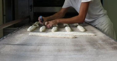 fırıncı ekmek yapma ve endüstriyel fırında pişirme. Organik el yapımı baget geleneksel Fransız tarzı lezzetli altın somun. Bütün tahıl yemek güzel altın gevrek.