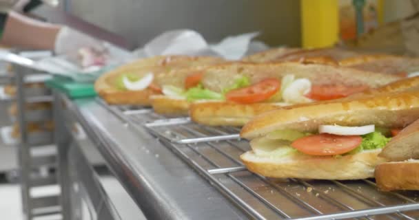 Herstellung von Sandwich mit Tomaten, Schinken, Käse, Salat, gekochten Eiern und Salat Zubereitung von Snacks, frischem Gemüse und Fleisch gesundes Fast Food, Mahlzeit sub Sandwich auf weißen und Weizen Hoagies. 