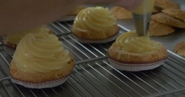 hamur işleri ve pastalar fırın mutfak, profesyonel iş ev yapımı tatlılar krem boru ve çikolata sosu şekerli dekorasyon baker güzel aperatifler sağlıksız yiyecek muamelesi yapıyor.