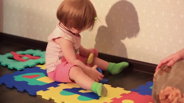 Een kind speelt met speelgoed op de vloer — Stockvideo