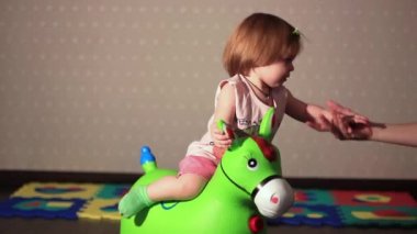 bir çocuk oyuncak at üstünde oturuyor