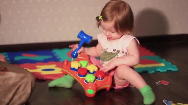 Uma criança brinca com um brinquedo no chão — Vídeo de Stock