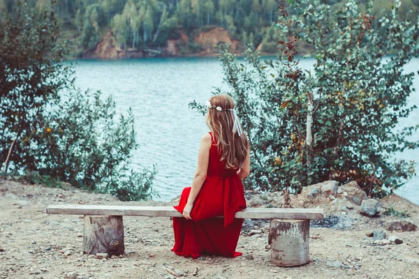 Mädchen im Kleid sitzt am See — Stockfoto