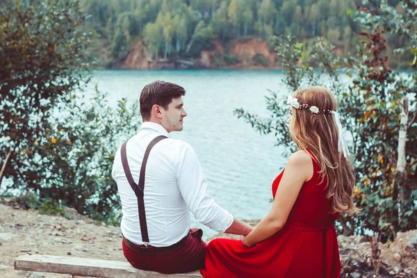 Lovers sitting by the water on the bench — Stock Photo, Image