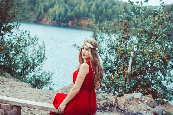 Mädchen im Kleid sitzt am See — Stockfoto