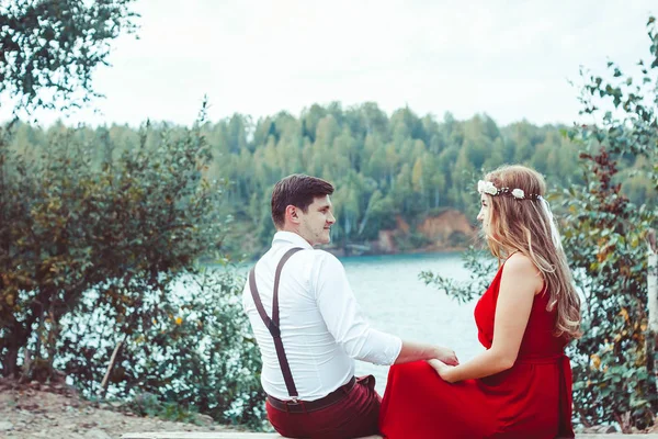 Casal sentado junto ao lago em um banco — Fotografia de Stock