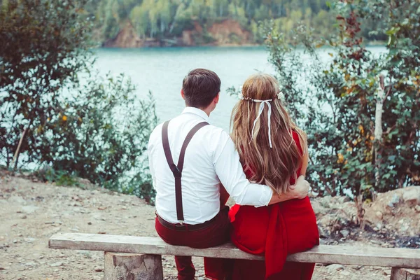 Lovers sitting by the water on the bench — Stock Photo, Image