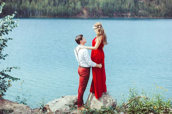 Coppia in piedi vicino ad un lago in un abbraccio — Foto Stock