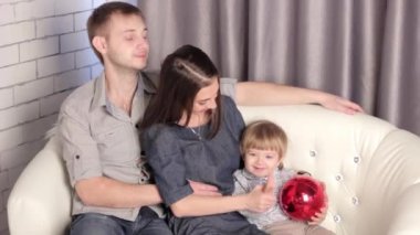 kanepede oturan bir çocuk ile bir aile