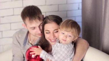 kanepede oturan bir çocuk ile bir aile