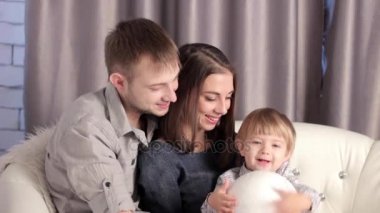 kanepede oturan bir çocuk ile bir aile