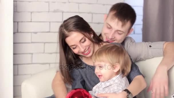 Kanepede oturan bir çocuk ile bir aile — Stok video