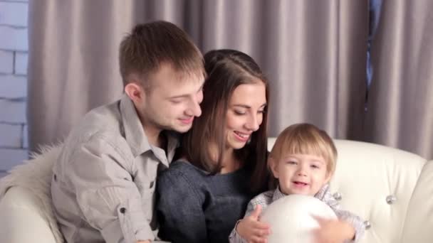 Kanepede oturan bir çocuk ile bir aile — Stok video