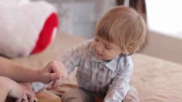 Padres con un niño jugando en la cama con juguetes — Vídeo de stock